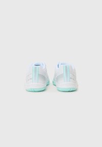 Baskets blanches de sport avec une tige en mesh texturé, accents bleu clair et semelle extérieure vert menthe. Présente des rayures verticales sur le talon.