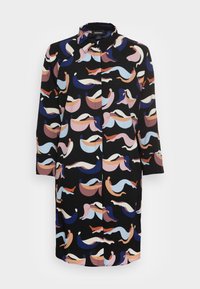 Schürzenkleid aus schwarzem Stoff mit einem bunten, abstrakten Wellenmuster in Pink, Blau und Lila. Mit Kragen und langen Ärmeln.