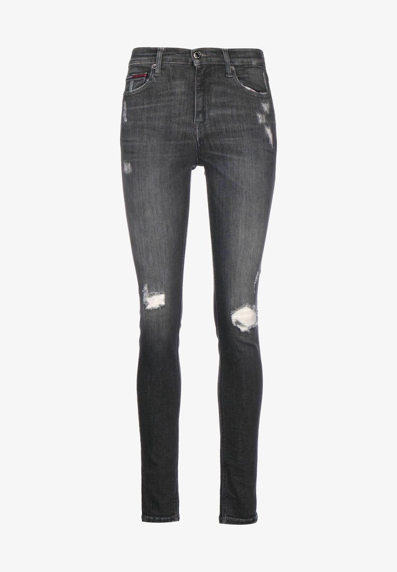 Jean skinny noir avec des patchs délavés et usés sur les cuisses et les genoux, cinq poches, et fermeture par bouton à la taille.