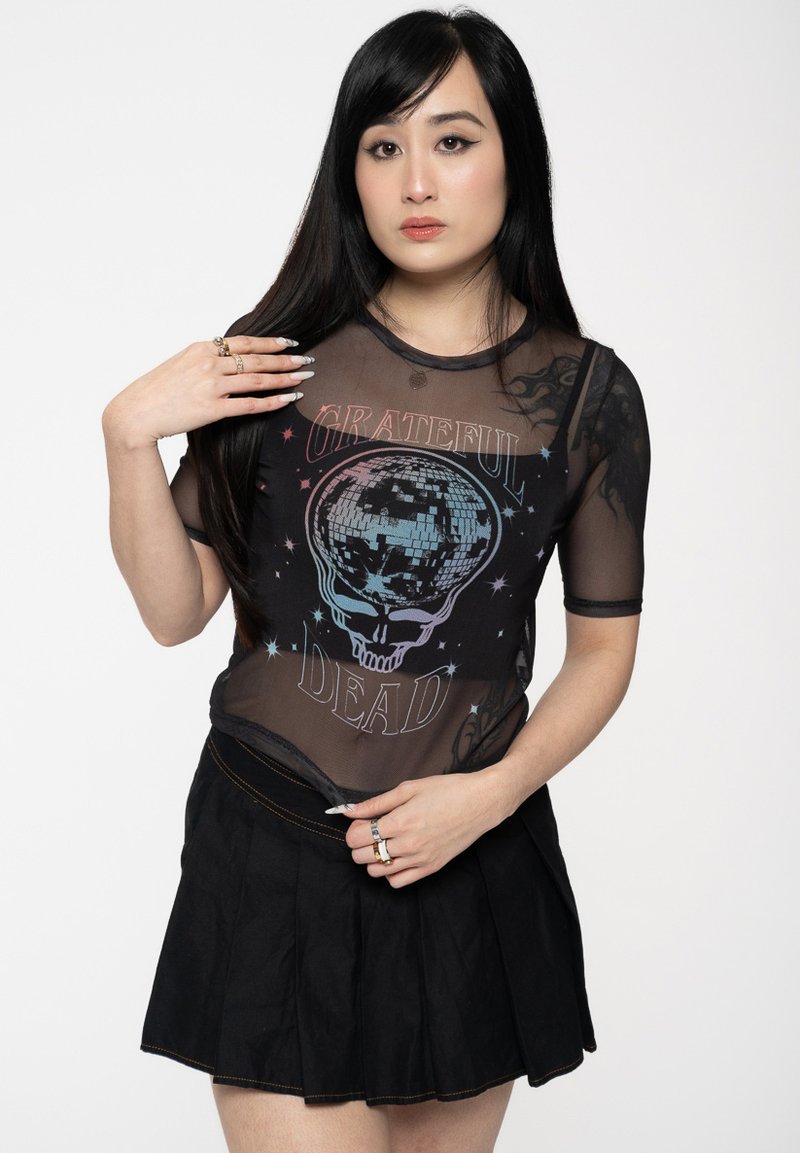 Black mesh t-shirt with colorful Grateful Dead graphic and a skull design, paired with a black pleated skirt, showing smooth textures and vivid colors.