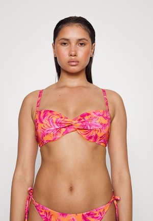 Conjunto de biquíni floral com um design de frente torcida. Tecido laranja vivo com padrões de folhas rosa. Alças ajustáveis e laços laterais nos calções.