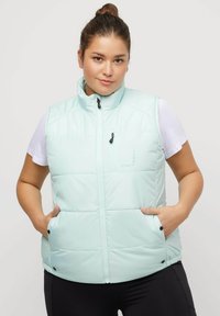 Gilet azzurro chiaro imbottito con colletto alto, zip frontale e tasche laterali. Texture liscia con finitura opaca e pannelli cuciti.