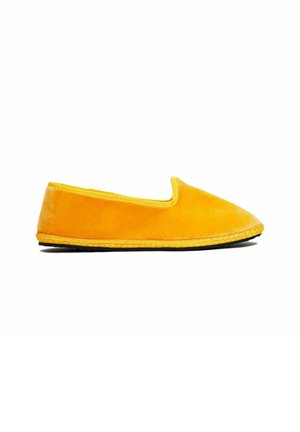 Scarpa gialla slip-on con una parte superiore morbida e testurizzata e un bordo giallo a contrasto. Suola flessibile con un dettaglio intrecciato lungo il bordo.