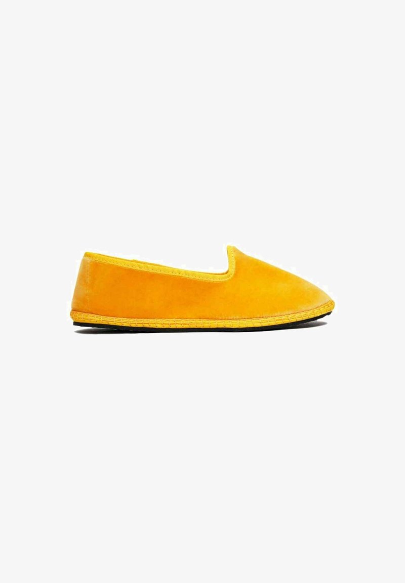 Chaussure jaune à enfiler avec une empeigne douce et texturée et un contour jaune contrastant. Semelle flexible avec un accent tissé le long du bord.
