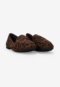 Mocasines con estampado de leopardo marrón, hechos de suave ante, con una suela negra de goma plana y flexible y una costura suave y ligeramente elevada en la parte superior.