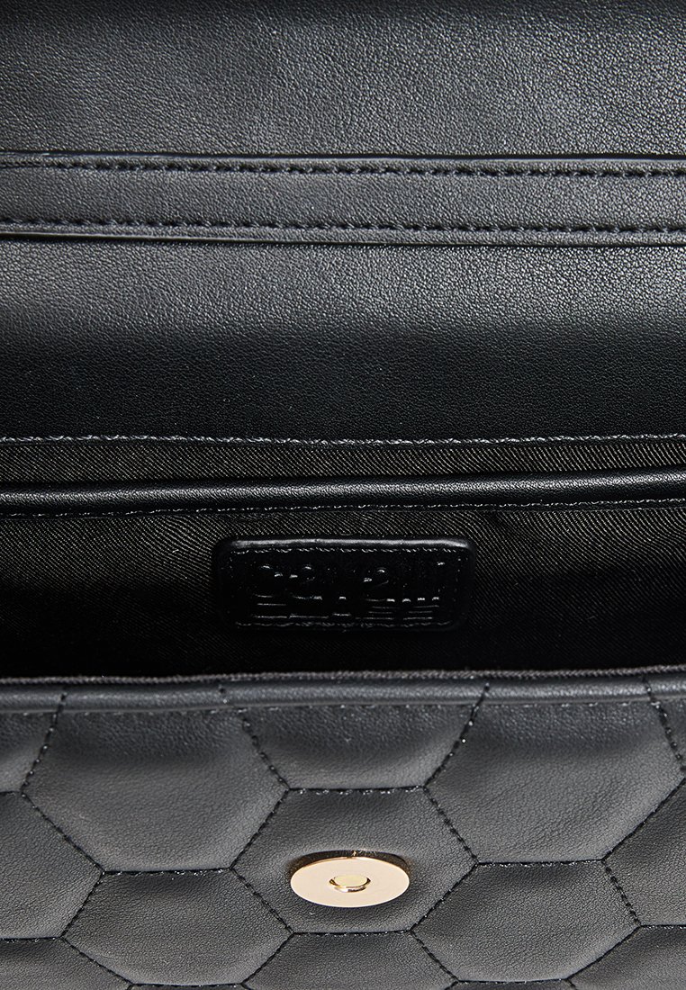 Bolso de cuero negro con un patrón texturizado hexagonal, que cuenta con un cierre de botón en tono dorado y una etiqueta de tela de la marca en el interior.