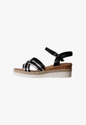 Black and silver strappy wedge sandal with ankle buckle, cork and braided rope midsole, and white textured rubber outsole.