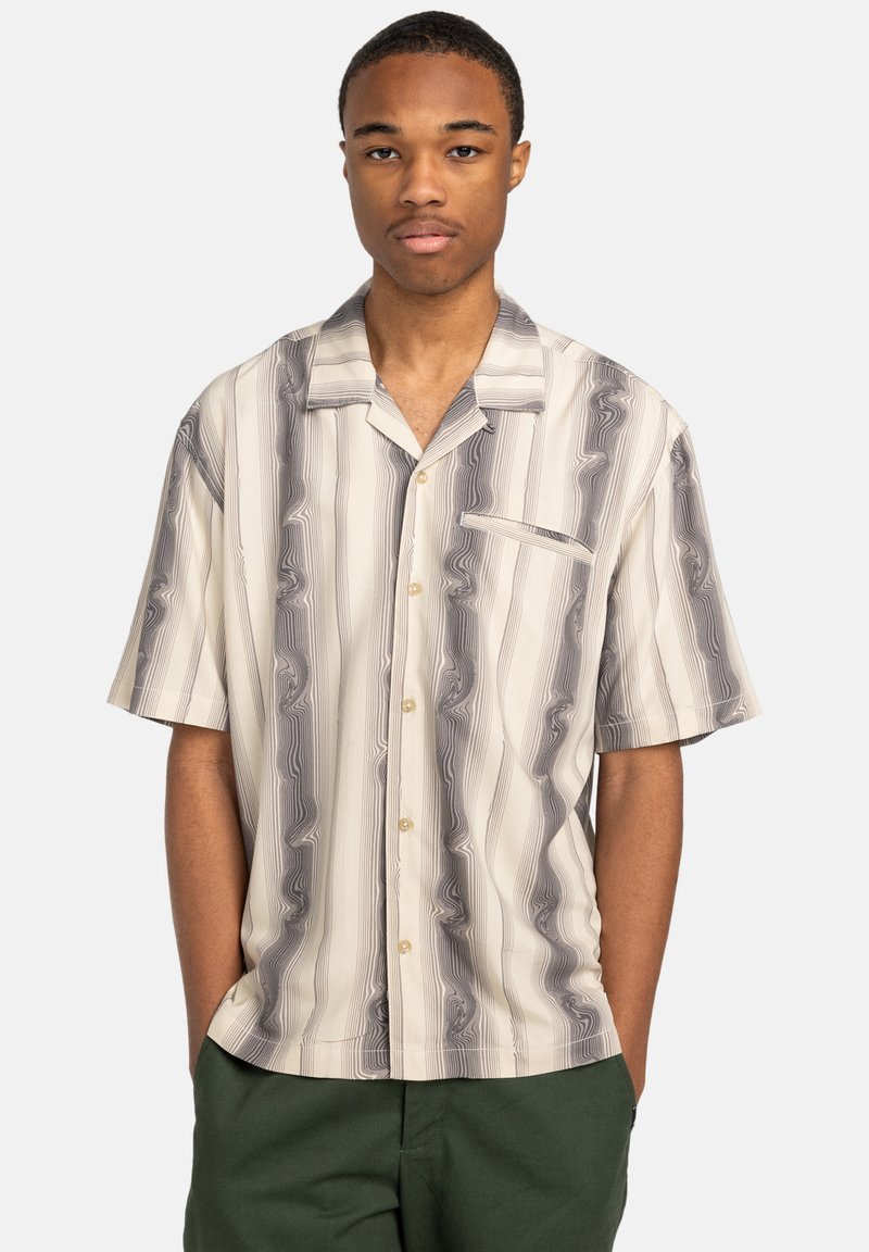 Short-sleeve shirt in cream and gray with wavy striped pattern, featuring a button-down front and a chest pocket. Made from lightweight fabric.