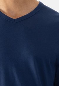 Marineblauwe t-shirt met een V-hals ontwerp. Gemaakt van een zachte, gladde stof, met een nette snit en minimale zichtbare naden.