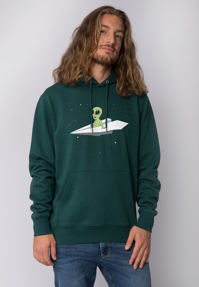 Groene hoodie van zacht materiaal, met een alienafbeelding die op een papieren vliegtuigje zit, voorzien van een voorzak en een trekkoordcapuchon.