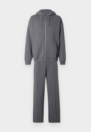 Fato de treino cinzento escuro de duas peças com capuz com fecho e cordões, e calças retas combinando.