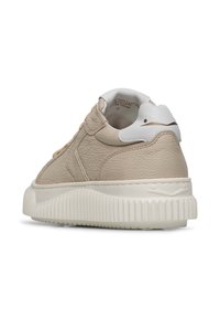 Sneaker in pelle beige con finitura testurizzata, suola in gomma bianca e dettaglio del tallone a contrasto. Presenta una forma arrotondata e accenti cuciti.