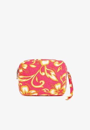 Piccola pochette rettangolare rosa da polso con motivo floreale giallo e bianco e chiusura con cerniera su sfondo bianco.