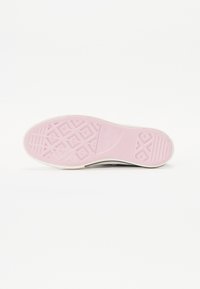 Schuhsohle mit einer rosa Gummibasis, die ein geometrisches Profilmuster und weiße Kanten aufweist. Glatte Textur mit geprägt Logo-Detail.