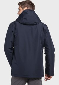 Marineblauwe waterdichte jas met capuchon, een soepele textuur en een rechte snit met een simpele silhouet en minimale naden.