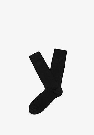 Czarne, sięgające do kolan skarpety wykonane z gładkiego, elastycznego materiału, z zaokrąglonym noskiem i ściągaczem u góry zapewniającym pewne dopasowanie. Bez wzorów i ozdób.