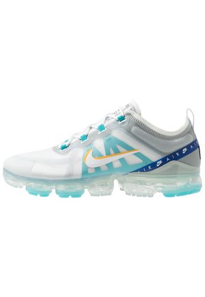 Hvid og turkis Nike Air VaporMax sneaker med gennemsigtig sål, orange swoosh og blå "AIR" branding på hælremmen.