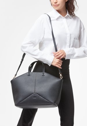 Borsa a spalla in pelle nera con forma strutturata, superficie testurizzata, doppio manico e una lunga tracolla regolabile. Presenta una base angolare distintiva.