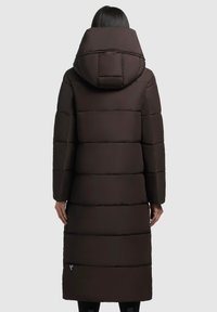 Manteau long en duvet de couleur marron foncé. Il présente une grande capuche, un design matelassé avec des panneaux horizontaux et un détail de fermeture éclair sur le côté au niveau de l'ourlet.