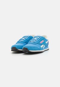 Pantofi sport albaștri, realizati dintr-o combinație de suede și materiale textile, cu accente albe, design cu șireturi și o talpă din cauciuc texturat negru.