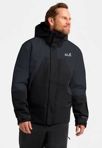 Black and navy waterproof jacket with a hood, featuring a front zipper, adjustable cuffs, and logo on the left chest. Durable fabric texture.