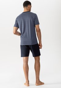 Navy blue patterned t-shirt with short sleeves and dark shorts. Fabric appears soft; t-shirt features small white squares pattern.
