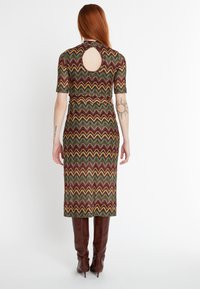 Strick-Midi-Kleid mit Zickzackmuster in Burgunderrot, Grün und Gelb; verfügt über kurze Ärmel und ein offenes Rücken-Design.