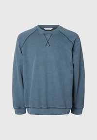 Sweat bleu col rond à manches longues avec détails de coutures visibles aux épaules et à la poitrine sur fond uni.