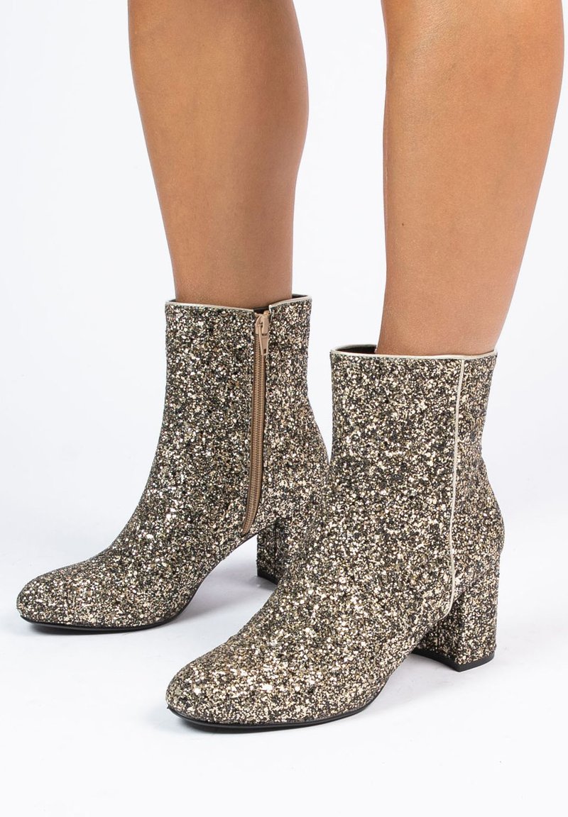 Glanzende enkelboots met een vierkante neus, bedekt met gouden en zilveren pailletten, met een zijrits en een stevige hak.