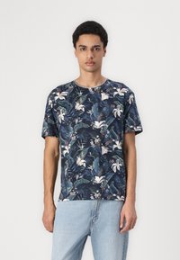 Tricou cu manșă scurtă, de culoare bleu închis, cu un model floral ce include crini albi și frunze verzi. Fabricat dintr-un material moale, cu decolteu rotund.