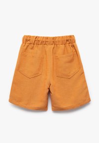 Shorts en coton orange avec une taille élastique, dotés de deux poches arrière et d'une texture douce et lisse. Ourlet droit au niveau des jambes.