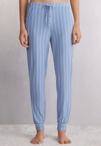 Lichtblauwe pyjamabroek met witte verticale strepen, elastische tailleband met koord, taps toelopende boorden, zachte stoftextuur.