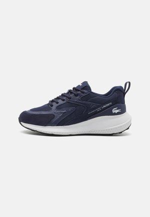 Lacoste sportschoen in marineblauw met een bovenwerk van textuurstof, een witte rubberen zool en logo-details op de hiel en zijkant.