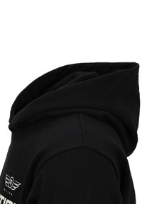 Zwarte hoodie met opgevouwen capuchon en zichtbare schoudernaad, met een wit logo en tekst op de borst.