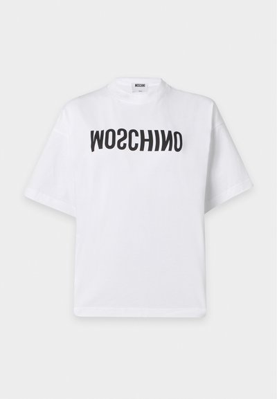 Бяла тениска с къс ръкав с черен изкривен текст MOSCHINO, отпечатан на гърдите и висока яка.