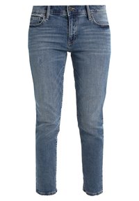 Jeans in denim azzurro chiaro con vestibilità slim, lavaggio scolorito, leggere abrasioni e design tradizionale a quattro tasche. Chiusura con bottone e zip.