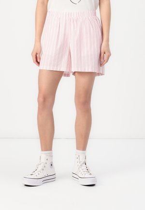Lyse rosa stripet shorts med elastisk midje, avslappet passform og sidelommer, paret med hvite høyhælte sneakers.