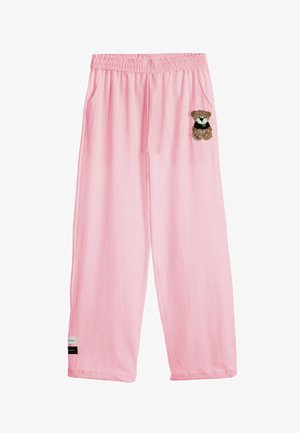 Pantalones anchos rosas con cintura elástica, bolsillos laterales, un pequeño gráfico de un osito de peluche en el muslo derecho y etiquetas en el dobladillo izquierdo.