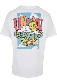 Hvit T-skjorte med et fargerikt grafisk design på baksiden, inklusive teksten "URBAN CLASSICS 2005," skyer og en solmotif.
