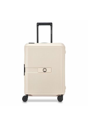 Maleta rígida de color crema con cuatro ruedas, asa negra extensible y cerradura central integrada en el panel frontal.