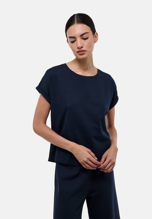 Haut bleu marine à manches courtes avec un col rond, coupe décontractée et manches repliées, fabriqué en tissu doux. Associé à un pantalon assorti.