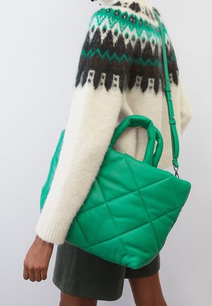 Groene gestikte tote bag gemaakt van soepel materiaal met een gestructureerd ontwerp, voorzien van twee handvatten en een afneembare schouderband.