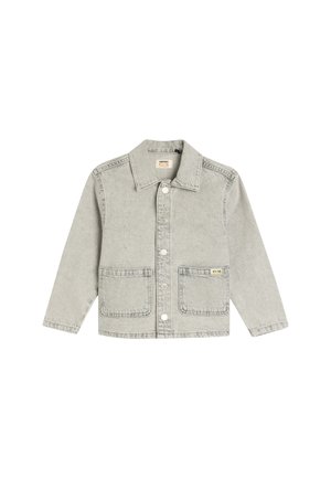 Veste en denim gris clair avec un col, fermeture centrale par boutons, deux poches avant et une petite étiquette jaune sur la poche gauche.