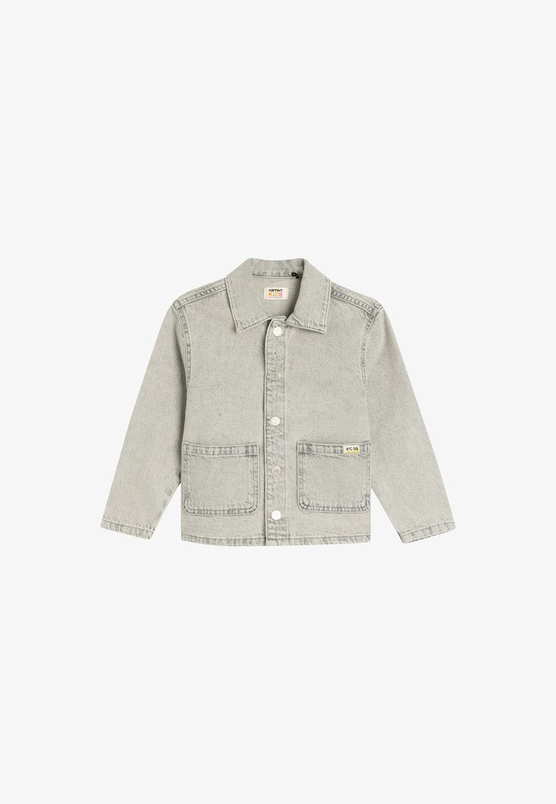 Chaqueta de mezclilla gris claro con cuello de solapa, cierre central de botones, dos bolsillos frontales y una pequeña etiqueta amarilla en el bolsillo izquierdo.