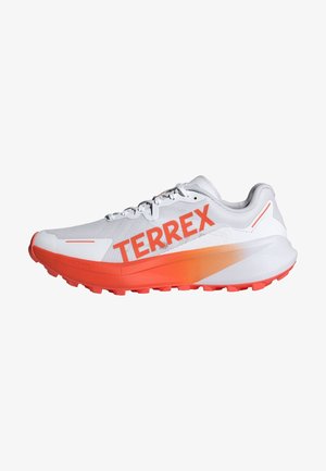 Witte hardloopschoen met feloranje accenten en "TERREX" merknaam. Voorzien van een gestructureerde mesh bovenwerk en een gevoerde zool met gripnoppen.