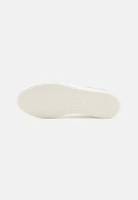 Hvit gummisåle til joggesko med et teksturert grep mønster og et sirkulært logo i midten. Glatt overflate med minimale designdetaljer.