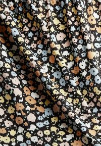 Tissu noir avec un petit motif floral dans des couleurs pastel telles que le jaune, le bleu et le rose, avec une surface texturée et douce.