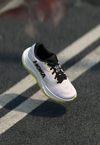 HOKA running shoe featuring a lightweight, breathable pink mesh upper, black accents, and a thick white midsole with yellow detailing.