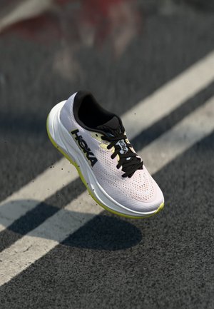 Chaussures de course HOKA avec un dessus en maille rose léger et respirant, des accents noirs et une semelle intermédiaire blanche épaisse avec des détails jaunes.