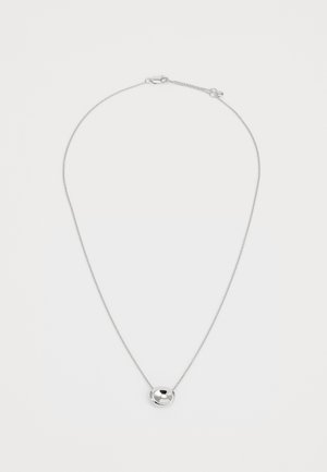 Collar de plata con una cadena fina y un colgante redondo, pulido, que presenta una superficie lisa y una indentación central.